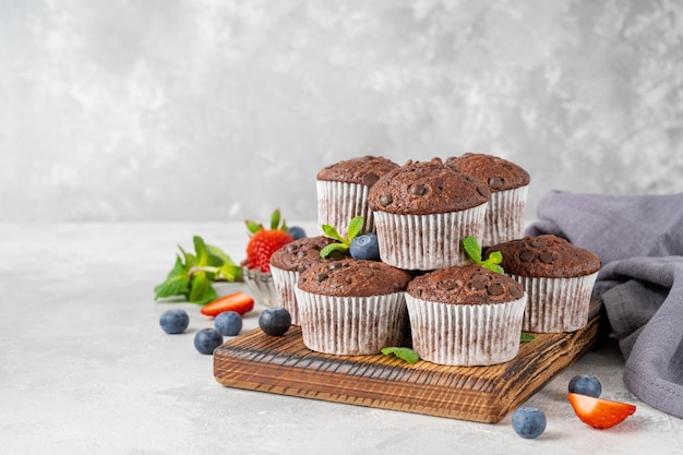Muffins de chocolate ou cupcakes com gotas de chocolate com frutas frescas e hortelã Copiar espaço
