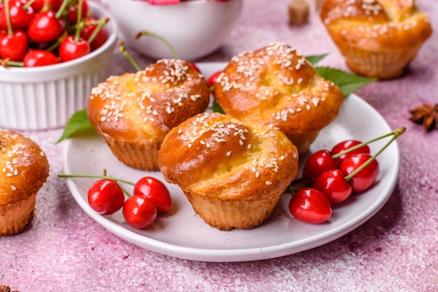 Muffins de farinha de arroz deliciosos frescos com cerejas em um fundo de concreto Pastelaria caseira