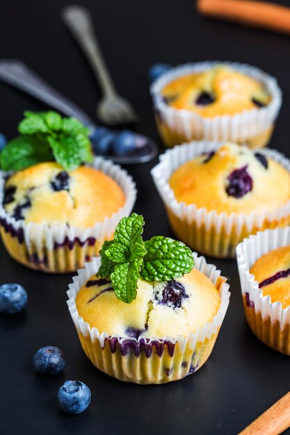 Muffins de mirtilos com açúcar em pó e bagas frescas