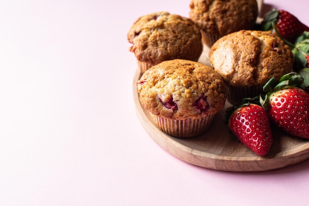 Foto muffins de morango servidos em um prato em um fundo rosa