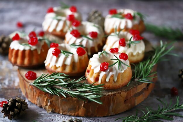 Muffins de Natal com alecrim, glacê branco e frutas vermelhas. Bolos de férias elegantes. Composição de Natal.