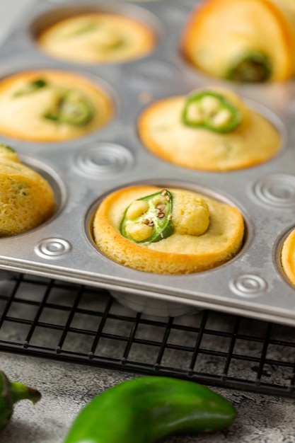 Muffins de pão de milho recém-assados com pimenta jalapeno picante na panela de muffin.