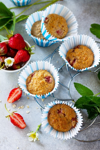 Muffins de sobremesa de verão com morango fresco na mesa de pedra ou concreto