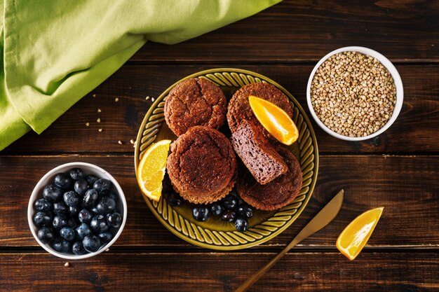 Muffins de trigo sarraceno vegan sem glúten na mesa de madeira escura