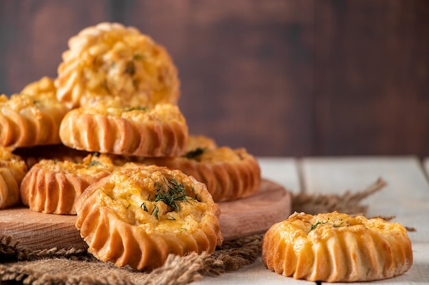 Muffins frescos com legumes e queijo em tábua de madeira Deliciosos bolos caseiros para dieta saudável Receita para prato sazonal de outono