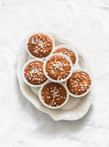 Muffins de harina de almendra con azúcar perla en un plato en un fondo claro vista superior