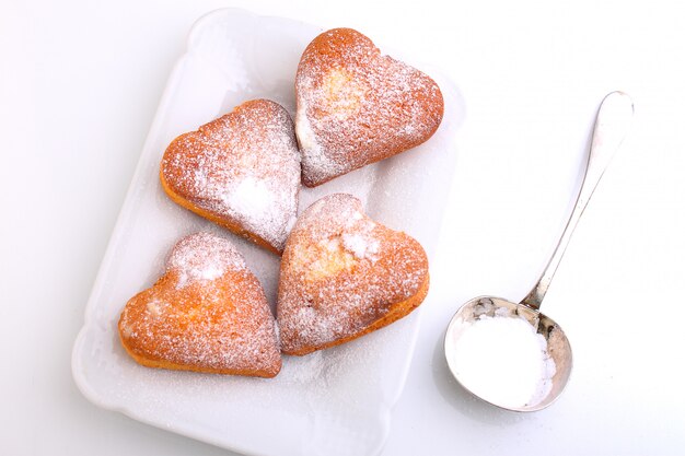 Muffins in Form von Herzen mit Puderzucker
