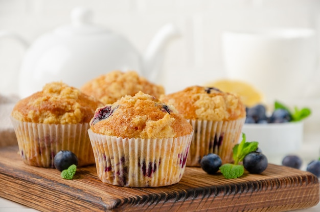 Muffins de limón con arándanos y shtreisel con bayas frescas sobre un fondo de madera blanca