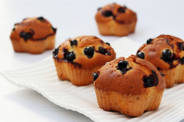 Muffins mit schwarzer Johannisbeere auf einem weißen Hintergrund, horizontales Foto