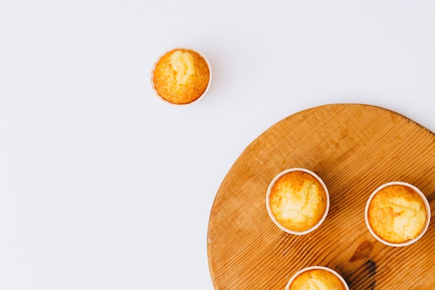 Muffins de naranjas caseros de minimalismo plano sobre tabla de madera