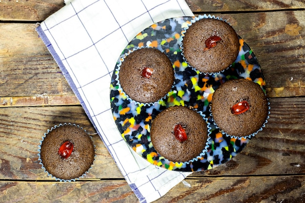 muffins de nueces de chocolate caseros decorados con cerezas confitadas en una mesa de madera nueces de chocolate caseras