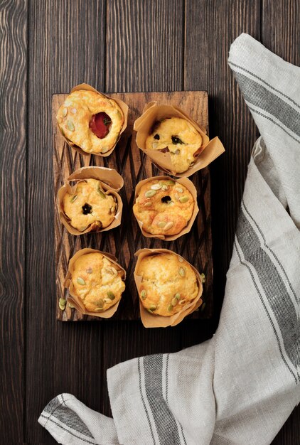 Muffins de queso saludable con polenta, tomate cherry y pipas de calabaza para el desayuno. Enfoque selectivo. Vista superior. Copie el espacio.