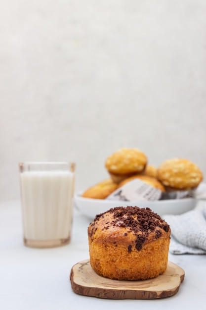 Muffins de vainilla y muffins con streusel con un vaso de leche
