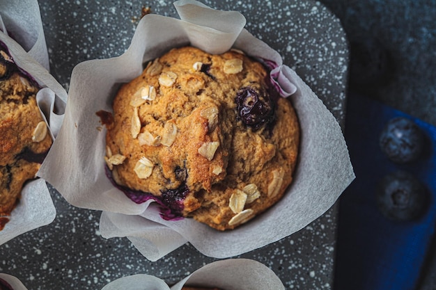 Muffins veganos de avena, plátano y arándanos sobre fondo azul Postre a base de plantas