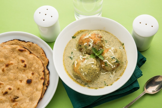 Mughlai o Haryanvi estilo Methi Malai Kofta en crema blanca, plato principal vegetariano indio popular servido en un tazón de madera con Chapati o Roti, enfoque selectivo