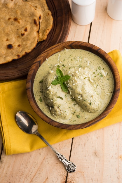 Mughlai o Haryanvi estilo Methi Malai Kofta en crema blanca, plato principal vegetariano indio popular servido en un tazón de madera con Chapati o Roti, enfoque selectivo