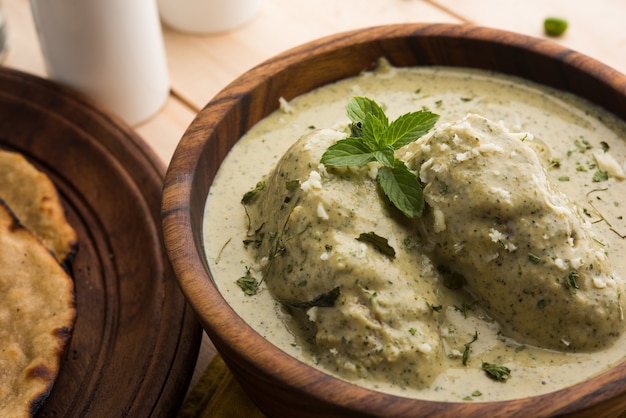 Mughlai o Haryanvi estilo Methi Malai Kofta en crema blanca, plato principal vegetariano indio popular servido en un tazón de madera con Chapati o Roti, enfoque selectivo