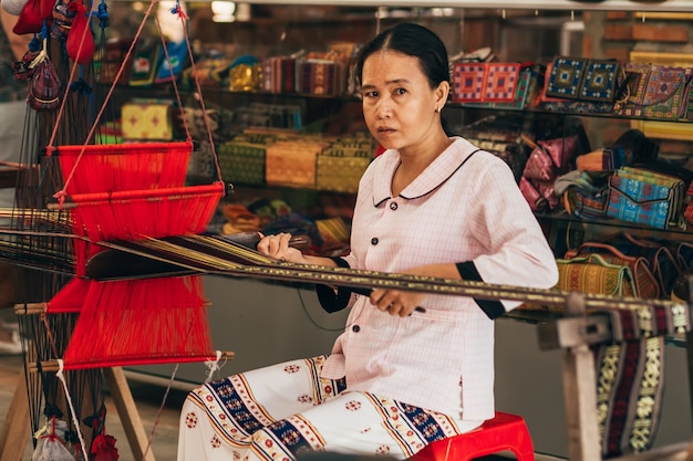 MUI NE, VIETNAM - 6. MÄRZ 2017: Frau asiatische Weber arbeitet an einem traditionellen Webstuhl für Garn Seide