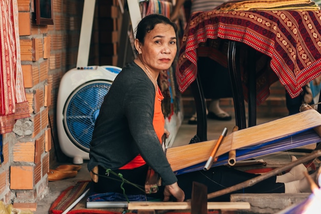 MUI NE, VIETNAM - 6 DE MARZO DE 2017: Tejedora trabajando en telares tradicionales para seda