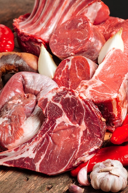 Muita carne fermentada suculenta fresca. Bifes de carne cozida em uma mesa de madeira