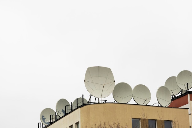 Muitas antenas parabólicas no telhado do edifício