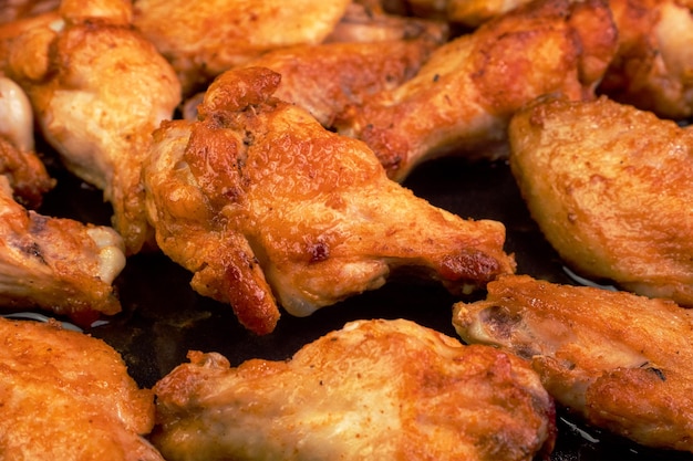 Foto muitas asas de frango fatiadas fritas com crosta crocante saboroso jantar saudável na cozinha doméstica