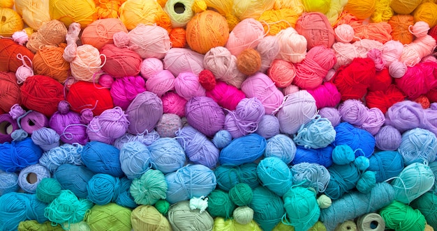 Muitas bolas coloridas de fios de lã e algodão