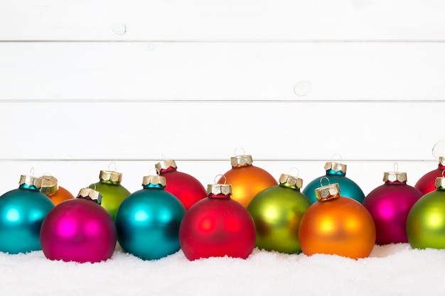 Muitas bolas de Natal coloridas decoração de fundo de madeira neve inverno