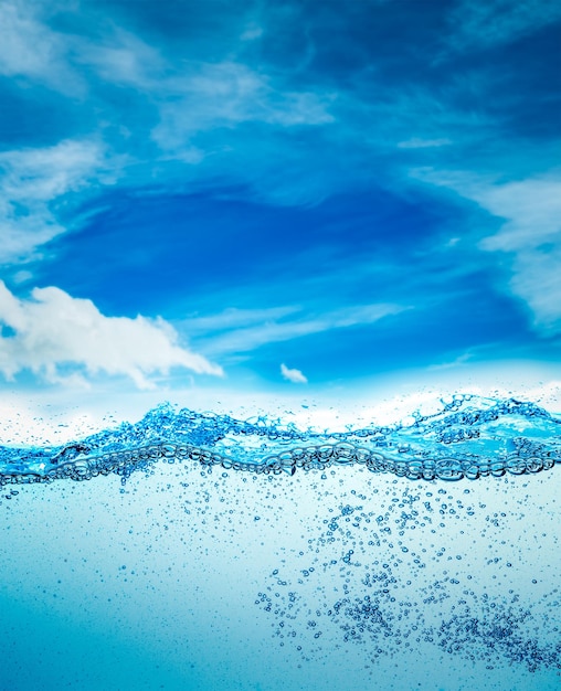 Muitas bolhas de ar na água de perto, onda de água abstrata com bolhas em um fundo de céu azul