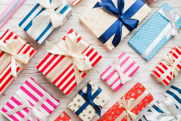 Muitas caixas de presente de Natal em papel colorido decorado na mesa, vista superior de perto. Muitos apresentam presentes de Ano Novo.