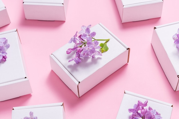 Foto muitas caixas de presente decoradas com flores lilás em fundo rosa