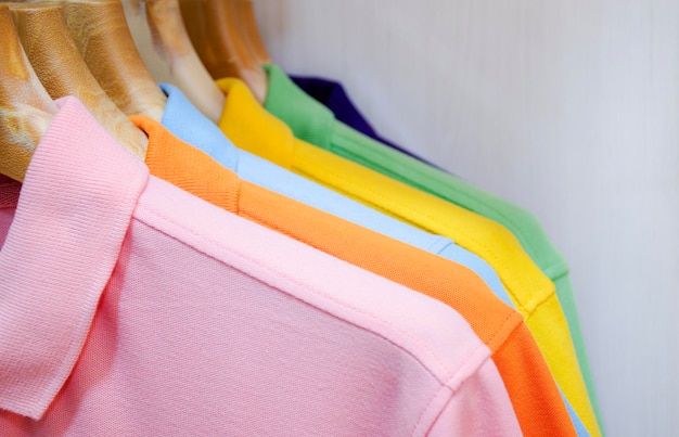 Muitas camisas coloridas penduradas em um rack