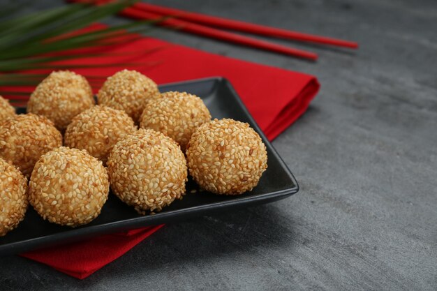 Muitas deliciosas bolas de gergelim em close-up de mesa preta Espaço para texto