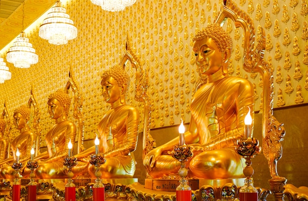 Muitas estátuas de Buda de ouro no templo no Museu Muangboran