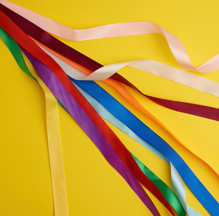 Foto muitas fitas multi-coloridas de seda no amarelo