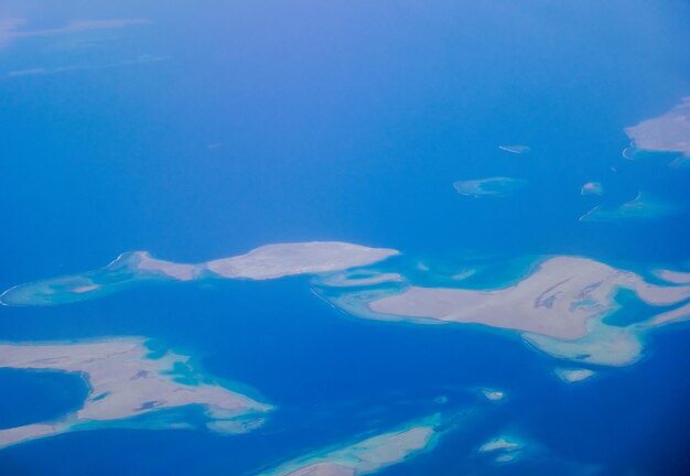 Foto muitas ilhas com recifes em uma vista do mar azul profundo durante um voo