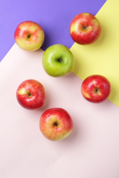 Muitas maçãs em um fundo colorido Maçãs vermelhas e verdes espalhadas em uma superfície colorida Frutas frescas para uma dieta saudável Vista superior