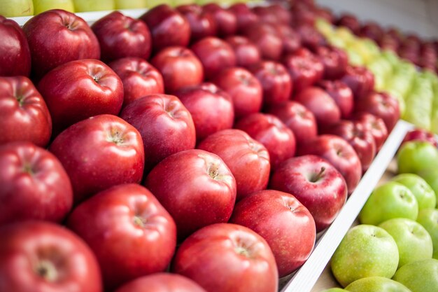 Muitas maçãs vermelhas lindamente estabelecidas no mercado no vento