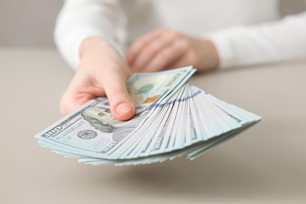 Muitas notas de dólar em mãos femininas fecham