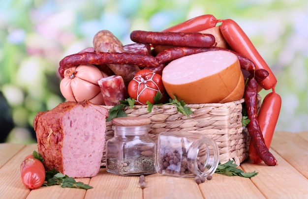 Muitas salsichas diferentes na cesta na mesa de madeira no fundo natural