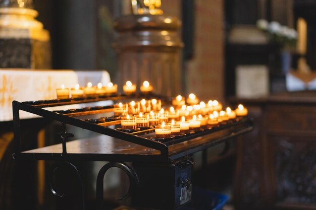 Muitas velas queimando em uma catedral Ritual religioso na igreja Conceito de fé, espiritualidade e religião