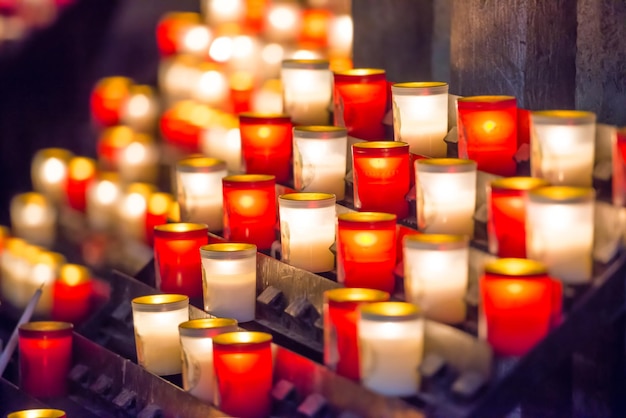 Foto muitas velas vermelhas e brancas brilhantes na igreja católica