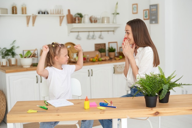 Muito bem. uma mãe empolgada elogia sua filha pelo progresso do dever de casa