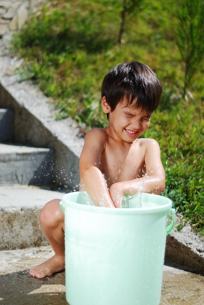 Muito bonito criança brincando com água ao ar livre