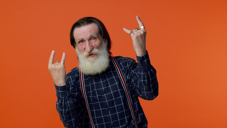 Foto muito feliz, encantado, louco, velho, mostrando um gesto de rock n roll com as mãos, dançando com sinais frios.