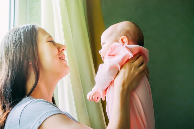 Muito feliz jovem segurando um bebê recém-nascido em seus braços