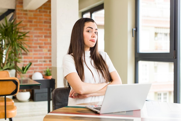 Muito jovem com um laptop trabalhando em casa design de interiores