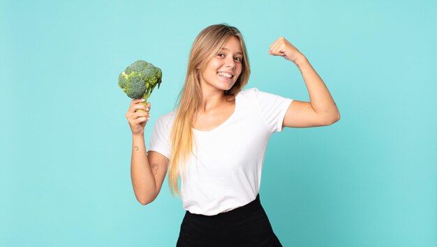 Foto muito jovem loira segurando um brócolis