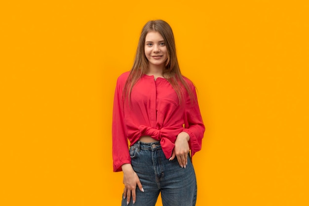 Muito jovem morena posando no retrato de estúdio de fundo de parede amarela Retrato de uma jovem sorridente