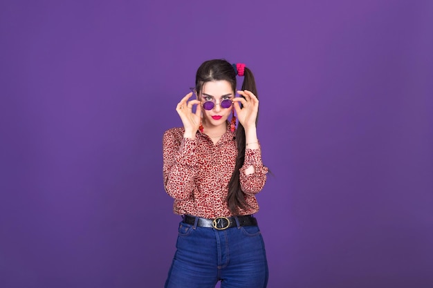 Muito jovem no estilo de moda retrô dos anos 90 sobre fundo de estúdio roxo